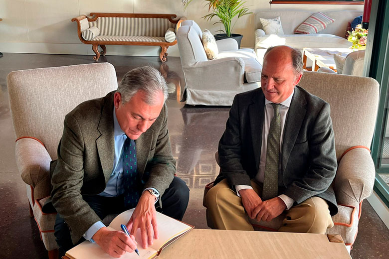 El alcalde de Sevilla junto al presidente, Rodrigo Molina, escribiendo en el libro de firmas de la Casa Club.